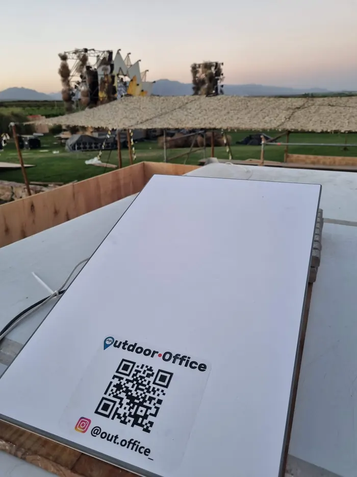 Antena satelital con el logo de Outdoor Office instalada en un evento