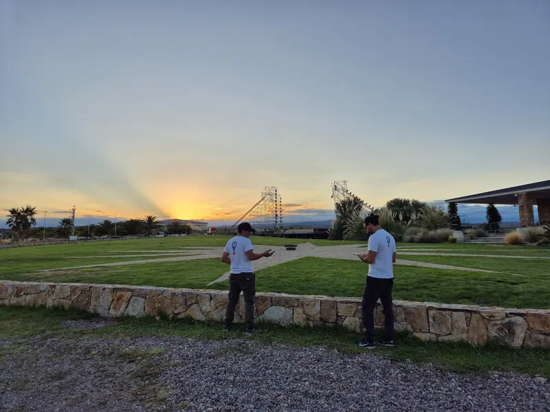 Dos técnicos de Outdoor Office configurando la red en un predio al atardecer